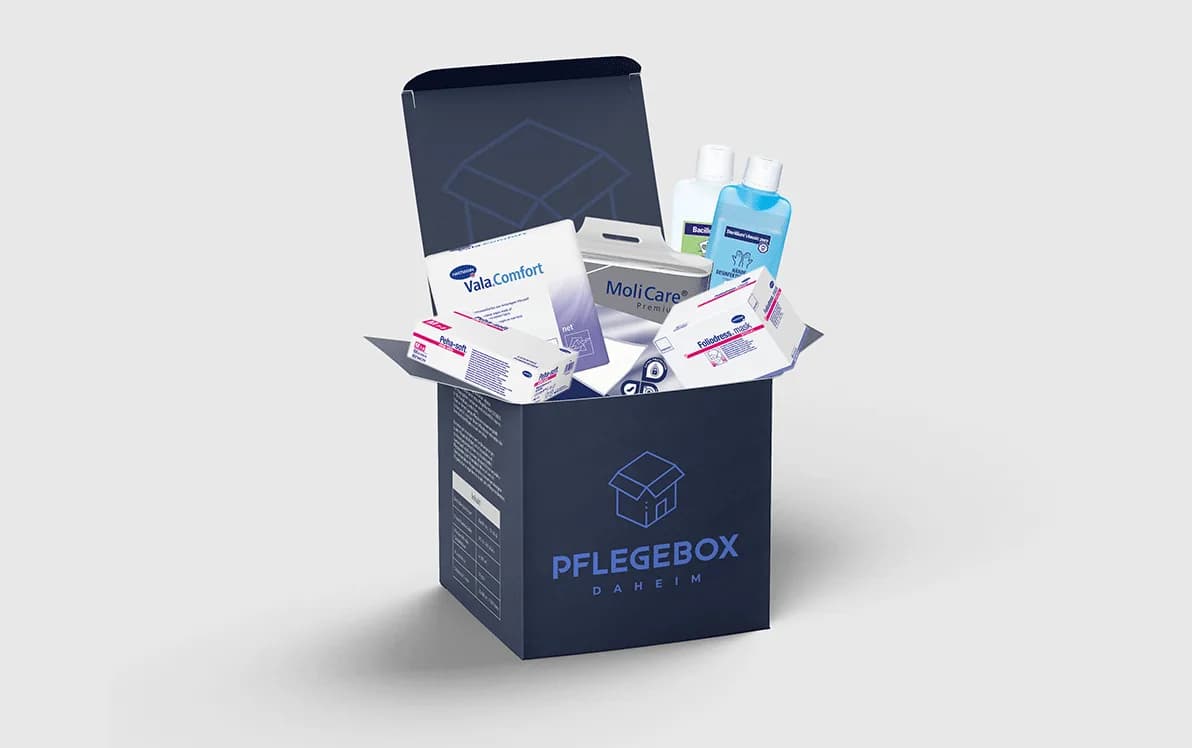 An open Pflegebox Daheim box packed with consumable care aids: disposable bed pads, hand disinfectant and hygiene products