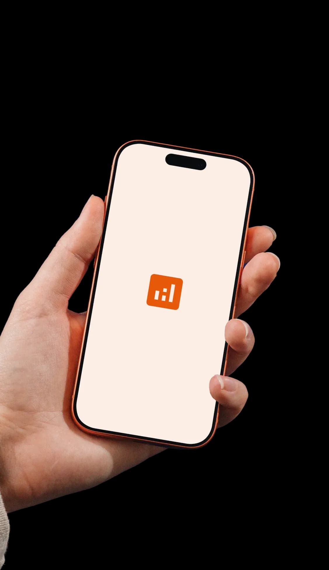 Hand holding a phone showing the orange TMS app icon on its launch screen