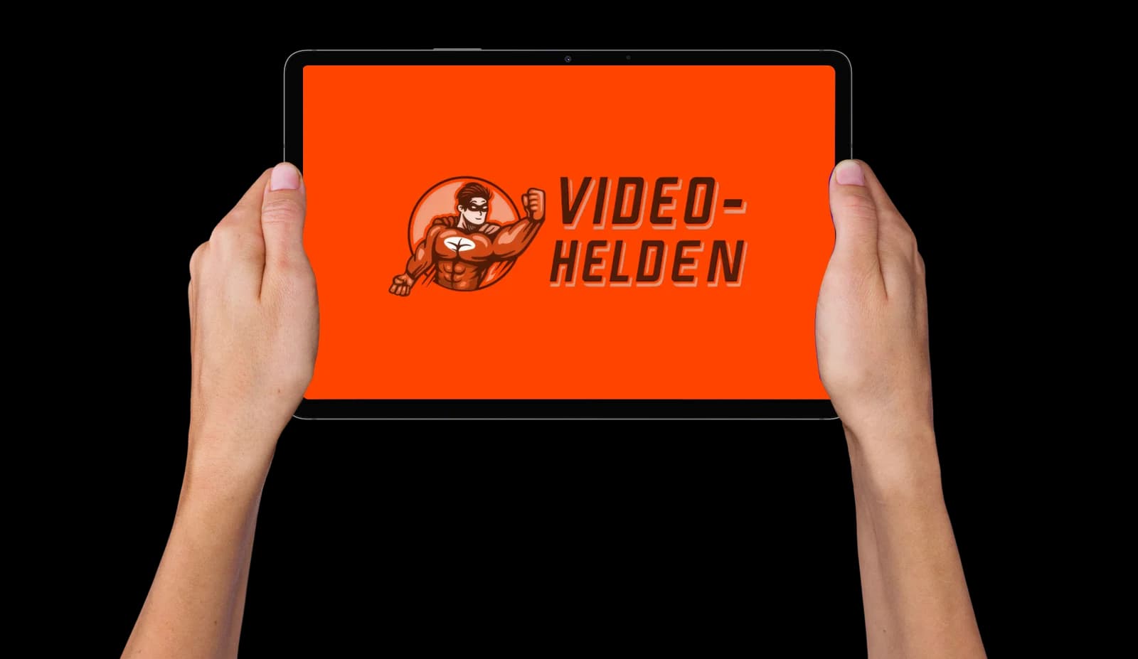 Two hands holding up a tablet showing the orange Video Helden splash screen with its superhero mascot